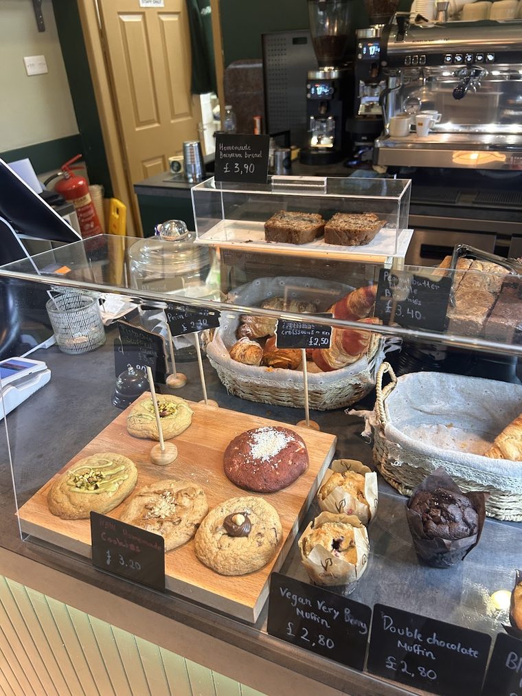 Cookies, brownies and traybakes on wooden boards and a tiered stand at the counter.